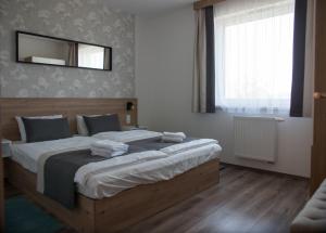 um quarto com uma cama grande e um espelho na parede em Lelle Resort B26 em Balatonlelle