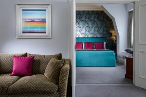 a bedroom with a bed and a couch in a room at Kilkenny Hibernian Hotel in Kilkenny