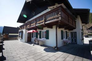 a building with a balcony and a table with an umbrella at Haus Bergland in St. Wolfgang