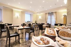 un restaurante con mesas, sillas y comida a la vista en Il Principe Hotel Catania, en Catania