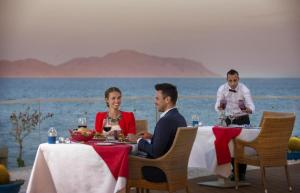 een man en een vrouw aan een tafel bij Sunrise Arabian Beach Resort in Sharm El Sheikh