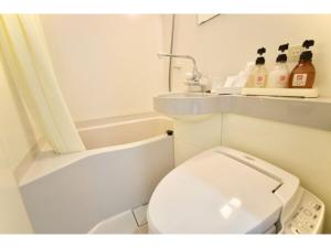 uma casa de banho branca com um WC e uma banheira em Hotel Frontier Iwaki / Vacation STAY 79266 em Iwaki