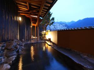 a house with a pool of water in front of a building at Ryokan Biyunoyado in Yamanouchi