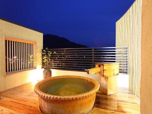 a large tub sitting on the floor of a balcony at Ryokan Biyunoyado in Yamanouchi