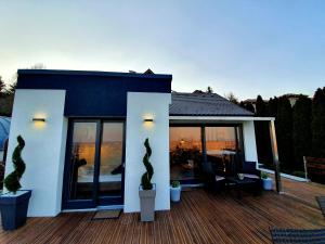 a house with a deck with a view of the ocean at Bagoly Wellness Apartman in Pécs