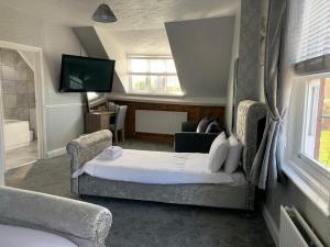 um quarto de hotel com uma cama e duas cadeiras em Grosvenor Hotel em Robin Hood's Bay