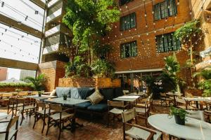 un patio avec des tables et des chaises en face d'un bâtiment dans l'établissement Rosa Malacca, à Malacca