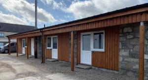 une rangée de portes et de fenêtres sur un bâtiment dans l'établissement Ivy Cottage-Serviced accommodation, à Dyce