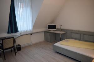 um quarto com uma cama e um computador numa secretária em Avenue Hotel em Nuremberga