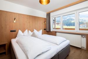 1 cama blanca grande en una habitación con ventana en Hotel Andreas, en Alpbach