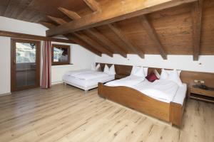 2 camas en una habitación con techos de madera en Hotel Andreas, en Alpbach