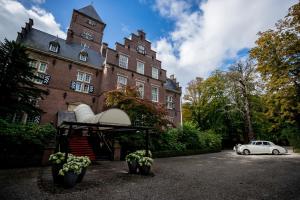 una macchina bianca parcheggiata di fronte a un edificio di Kasteel de Wittenburg a Wassenaar