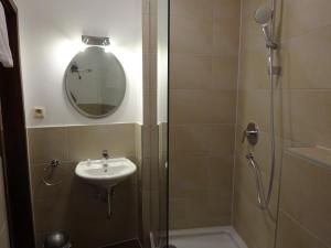 bagno con doccia, lavandino e specchio di Hotel Weingärtner a Mannheim