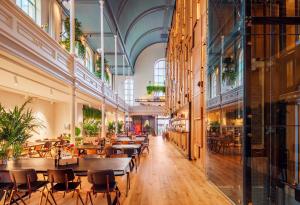 a restaurant with tables and chairs in a building at Bunk Hotel Utrecht in Utrecht