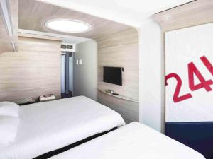 Cama ou camas em um quarto em ibis Styles La Rochelle Centre