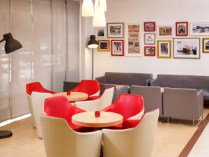 a restaurant with two tables and red chairs at ibis Southampton in Southampton