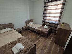 een kamer met 2 bedden en een raam bij Hatvan Corner Apartments 2 in Debrecen