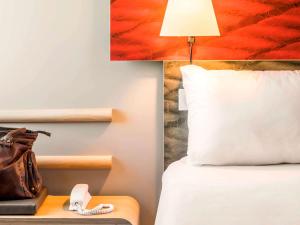 ファロにあるHotel ibis Faro Algarveのホテルルーム(ランプと電話付きのベッド付)