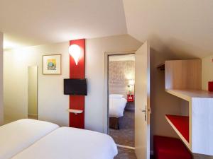 a hotel room with a bed and a room with a bedroom at ibis Styles Ouistreham in Ouistreham