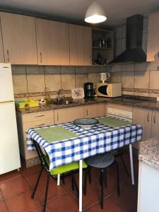 una cucina con tavolo e panna a scacchi di Casa Da Estela a Carrapateira