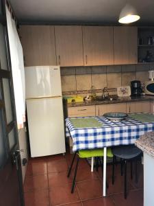 una piccola cucina con tavolo e frigorifero di Casa Da Estela a Carrapateira