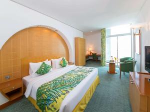 una camera d'albergo con letto e TV di Mercure Grand Jebel Hafeet Hotel a Al Ain