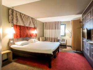 ein Hotelzimmer mit einem großen Bett und einem roten Teppich in der Unterkunft ibis Rouen Centre Champ de Mars in Rouen