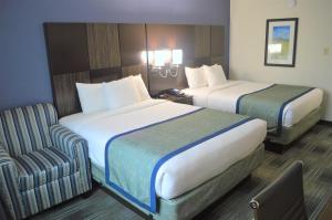 a hotel room with two beds and a chair at Falmouth Inn in Falmouth