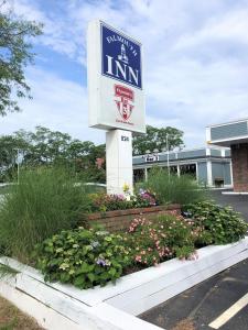 a sign in a flower bed in front of a inn at Falmouth Inn in Falmouth