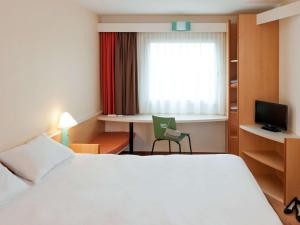 A bed or beds in a room at ibis Fribourg