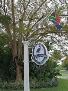 a sign with a flag on top of a pole at St. Lucia Wetlands Guest House in St Lucia