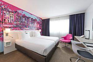 een hotelkamer met een groot bed en een bureau bij WestCord Art Hotel Amsterdam 3 stars in Amsterdam