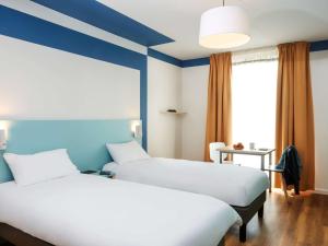 A bed or beds in a room at Aparthotel Adagio Access Strasbourg Illkirch