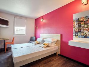 1 dormitorio con 1 cama con pared de color rosa en hotelF1 Genève Saint Julien en Genevois, en Viry