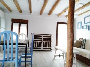 a dining room with a table and blue chairs at Casa Rural Teresa in El Molar