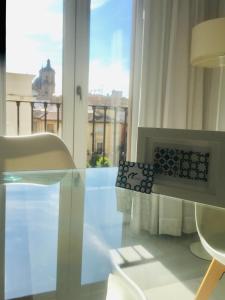 uma sala de estar com uma mesa de vidro e uma lareira em Domus Apartamentos Granada con parking gratuito en pleno centro em Granada