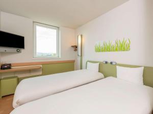 A bed or beds in a room at ibis budget Bern Expo