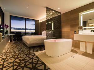 baño con bañera, cama y lavamanos en Pullman Sydney Airport, en Sídney