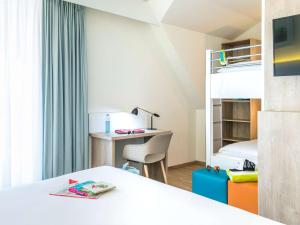 a bedroom with a bed and a desk and a bunk bed at ibis Styles Nieuwpoort in Nieuwpoort