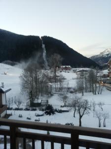 a snow covered field with a waterfall in the distance at Appartamento Mariastella in Andalo