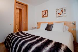 Un dormitorio con una cama grande con una manta de cebra. en Apartaments Ashome, en Canillo