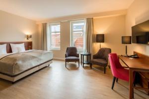 um quarto com uma cama, uma secretária e cadeiras em Best Western Plus Hotel Excelsior em Erfurt