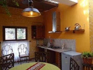 a kitchen with yellow walls and a table and a counter at Hostal Bivouac in La Paz