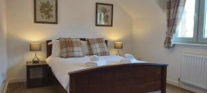 een slaapkamer met een bed met twee handdoeken erop bij Loch Ness Abbey Cottages in Fort Augustus