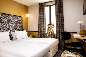 um quarto de hotel com duas camas e uma janela em Hôtel Paris La Fayette em Paris