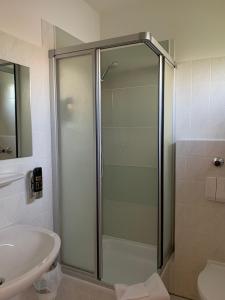 La salle de bains est pourvue d'une douche et d'un lavabo. dans l'établissement Hotel Toskana, à Wiesbaden