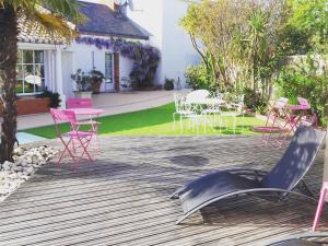 een terras met roze stoelen en tafels en stoelen bij Le Manoir de l'antiquité in Challans