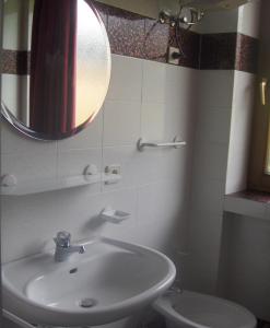 y baño con lavabo, espejo y aseo. en Residenze Sonnenschein Casa Bianca, en Villabassa