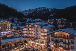 uma vista para um resort com edifícios cobertos de neve em Sporthotel Romantic Plaza em Madonna di Campiglio