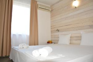 um quarto com uma cama branca e toalhas em Milennia Family Hotel em Sunny Beach